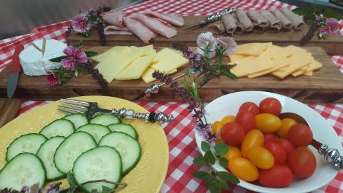 a table topped with plates of cheese and vegetables at Bella Manga Country Escape in Plettenberg Bay