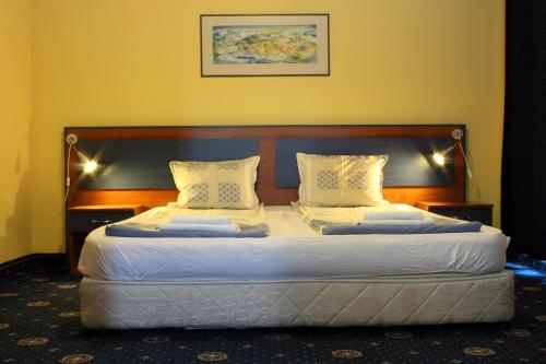 a bedroom with two beds with white sheets and pillows at Fenix Family Hotel in Blagoevgrad