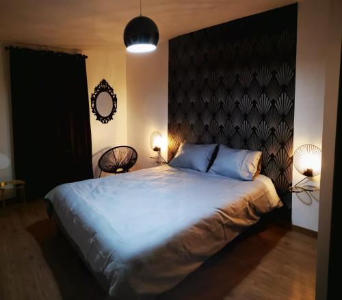 Schlafzimmer mit einem großen Bett mit einem schwarzen Kopfteil in der Unterkunft Appt 2 pièces à 18 mn du château de Versailles in Le Port-Marly