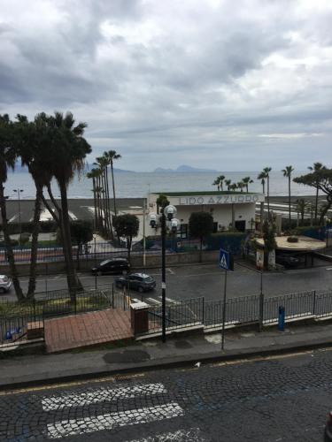 a view of a street with palm trees and a building at Vient e mare (Sea wind) in Torre Annunziata