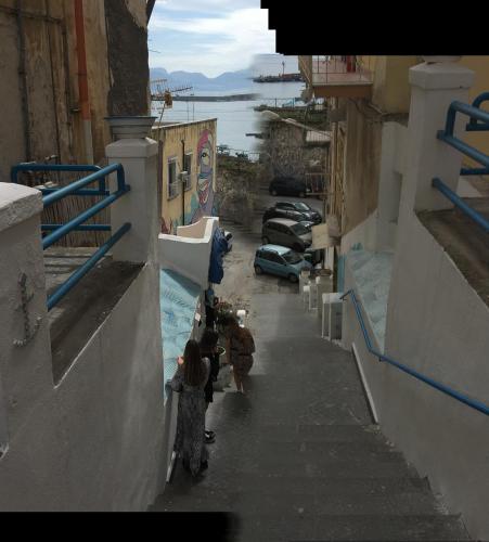 a group of people walking down a alley with cars at Vient e mare (Sea wind) in Torre Annunziata