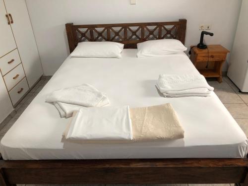 a bed with white sheets and white towels on it at Mythos Suites-Hermes apartment in Methoni