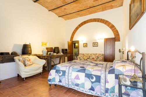 - une chambre avec un lit et une chaise dans l'établissement Tenuta Di Argiano A Montepulciano, à Chianciano Terme