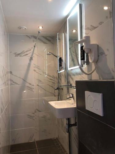 a bathroom with a sink and a shower at Facade Hotel Amsterdam in Amsterdam