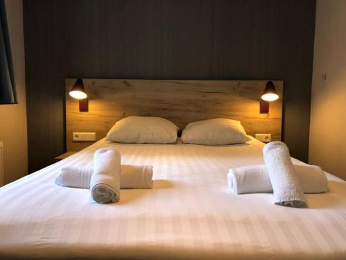 a large white bed with two towels on it at Facade Hotel Amsterdam in Amsterdam