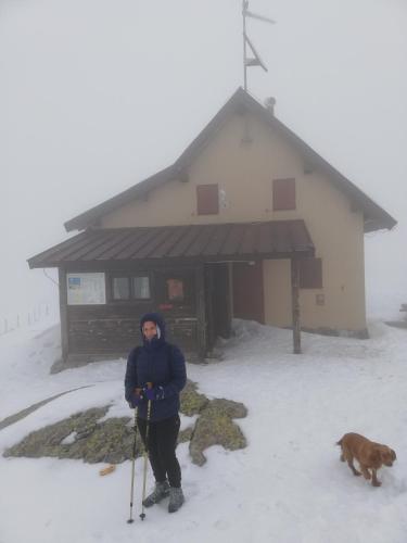 a woman standing in the snow in front of a building at Chalet Il Fungo in Averara