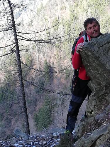 a man leaning against a rock on a mountain at Chalet Il Fungo in Averara
