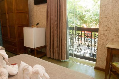 a bedroom with a bed and a window with a balcony at Pousada Brasil Nativo in Cabo Frio