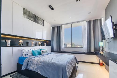 a bedroom with a bed and a flat screen tv at FREE Netflix Condo near IT Park with 32-inch Samsung HDTV in Cebu City