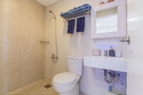 een badkamer met een toilet, een wastafel en een douche bij FREE Netflix Condo near IT Park with 32-inch Samsung HDTV in Cebu City