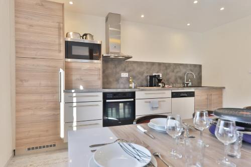 a kitchen with a table with wine glasses on it at Locations des 3 sommets avec Sauna et Spa en Alsace in Sondernach