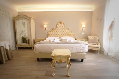 Schlafzimmer mit einem Kingsize-Bett und einem Tisch in der Unterkunft Hotel Villa Margherita in Quercianella