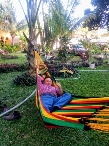 a woman laying in a hammock on the grass at Casa Palagui Colonial in Valladolid