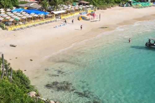 an aerial view of a beach with people in the water at CANTO DA ARVORE 1 in Arraial do Cabo