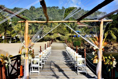 a wooden walkway with white chairs on a beach at Calabash Cove Resort and Spa - Adults Only in Gros Islet