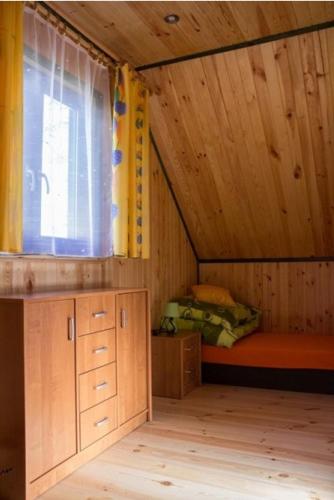 a small room with a bed and a window at Sosnowa Oaza in Baranów Sandomierski
