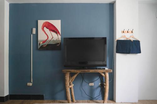 a tv sitting on a table in a room at Dulan The Travel Bug Bistro Inn in Donghe
