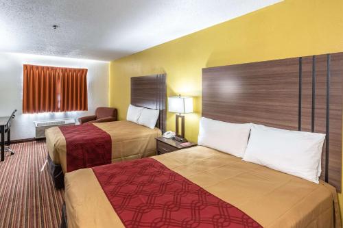 a hotel room with two beds and a desk at Econo Lodge Inn & Suites in McKinney