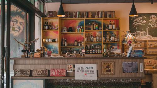 Una tienda con un mostrador con alcohol. en Dulan The Travel Bug Bistro Inn en Donghe