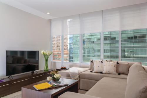 a living room with a couch and a table at Botticelli Tower By The Local Way in Mexico City