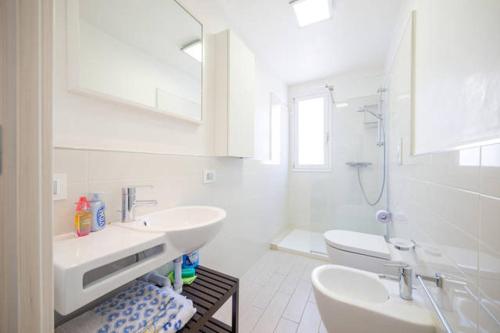 a white bathroom with two sinks and a shower at Casa Grazia Letojanni Centro in Letojanni