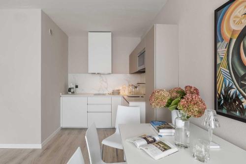 a white kitchen with a white table and chairs at Residence Toblini in Nago-Torbole