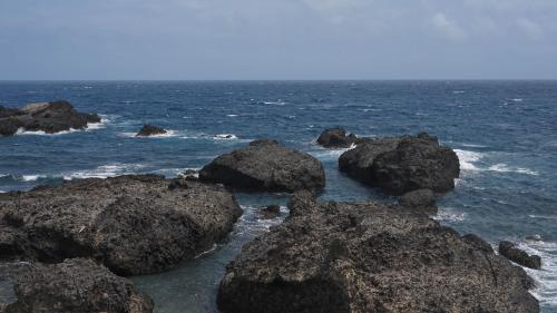 a group of rocks in the ocean near the shore at Dulan The Travel Bug Bistro Inn in Donghe