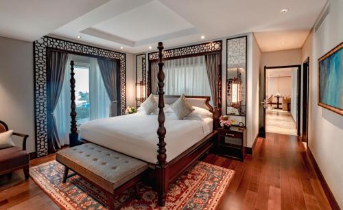 a bedroom with a canopy bed and a living room at Taj Coromandel in Chennai