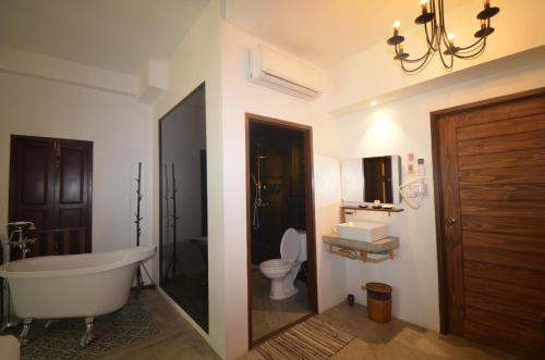 a bathroom with a bath tub and a toilet at Moonlight Champa Riverview in Luang Prabang