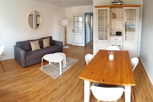 ein Wohnzimmer mit einem Tisch und einem Sofa in der Unterkunft Ferienwohnung *Windstille* in Wittdün