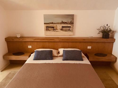 a bedroom with a bed with two blue pillows at Cavour 96 in Mantova