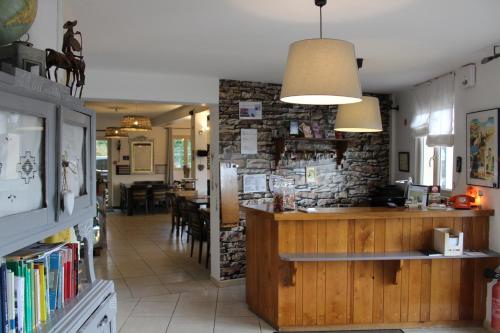 un restaurant avec un bar et un mur en pierre dans l'établissement Hotel La Peyrade, à Cajarc