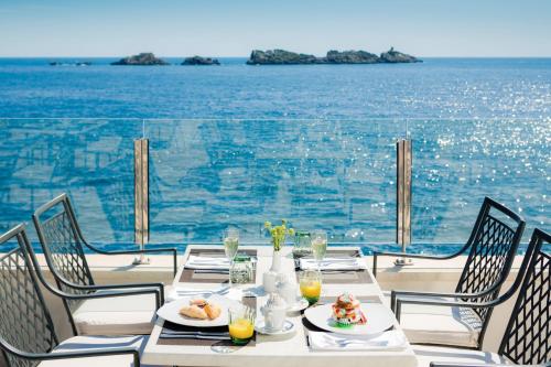 a table with food and a view of the ocean at Royal Ariston Hotel in Dubrovnik