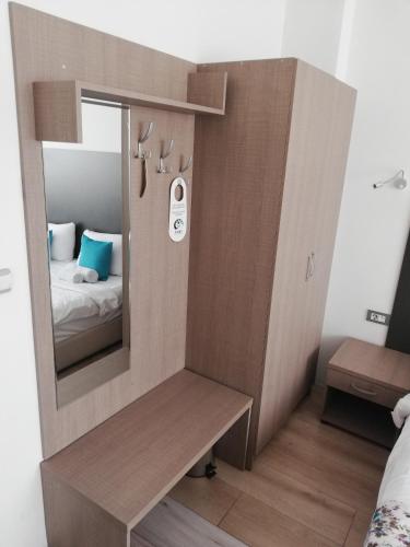 a small room with a mirror and a bed at Atlas City Center Hotel in Prilep
