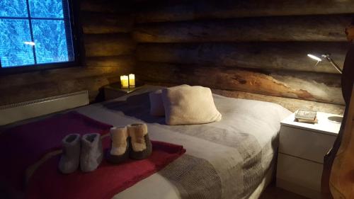 Un dormitorio con una cama con zapatos encima. en Villa Amo by the lake, en Ruka