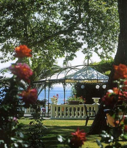 a garden with a gazebo and a white fence at Hotel Lido - Beach and Palace in Bolsena