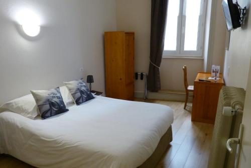a bedroom with a large white bed with blue pillows at Hotel des Alpes in Die
