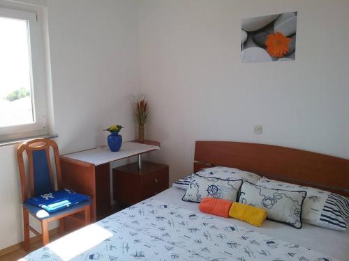 a bedroom with a bed and a table and a window at Apartment Fanny in Baška Voda