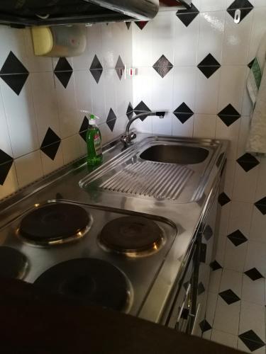 a kitchen with a stove and a sink at Condominio Royal ristrutturato in Sestriere