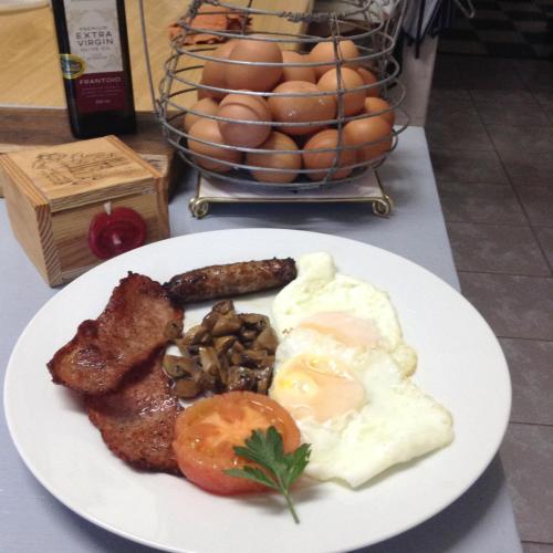 a plate of breakfast food with eggs meat and mushrooms at Gerald's Gift Guest House in Addo