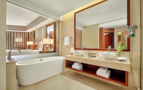 a bathroom with two sinks and a large mirror at Fairmont Ajman in Ajman 