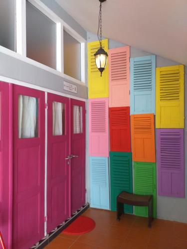 a room with brightly colored doors and a bench at Home Addicts Hostel in Yogyakarta