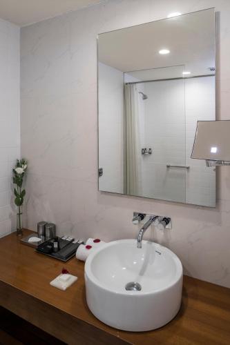 a bathroom with a white sink and a mirror at The Park Navi Mumbai in Navi Mumbai