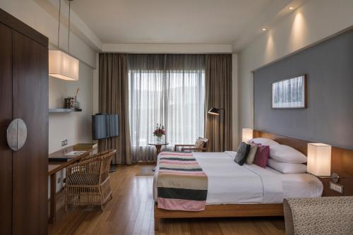 a hotel room with a bed and a desk at The Park Navi Mumbai in Navi Mumbai