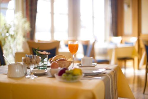 a table with a plate of food and a glass of orange juice at Göbels Hotel zum Löwen in Friedewald