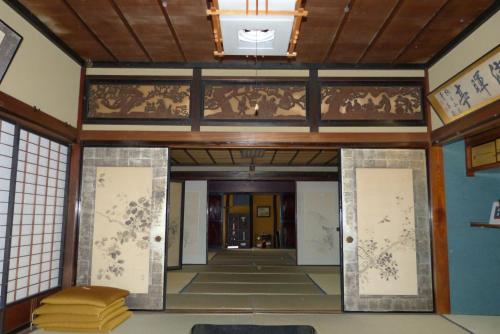 an entrance to a building with a painting on the wall at Guesthouse Higashi Fujitatei in Shinonsen