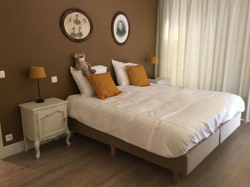 Un dormitorio con una cama con un osito de peluche. en vakantiehuis-oyenkerke 2 en De Panne