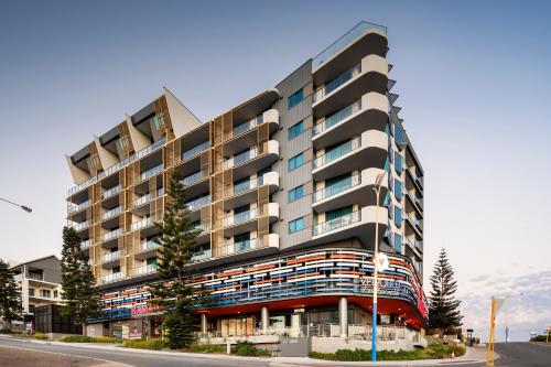 a large building with a lot of windows on the side of it at Ramada by Wyndham VetroBlu Scarborough Beach in Perth