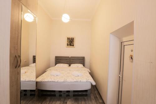 ein kleines Schlafzimmer mit 2 Betten und einem Spiegel in der Unterkunft L&L Apartment in Tbilisi City