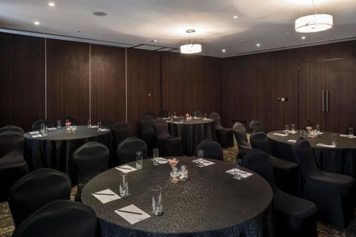 a conference room with tables and chairs in a room with wooden walls at The Park Navi Mumbai in Navi Mumbai